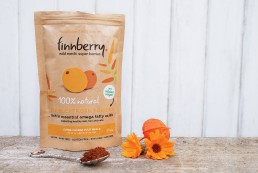 A photo of the finnberry sea buckthorn pack, next to spoon and flowers