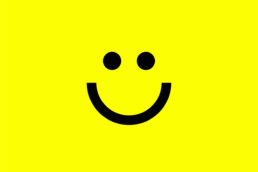 Happy Marketer smiley face icon in black on a yellow background created by branding agency DBC Creative Agency